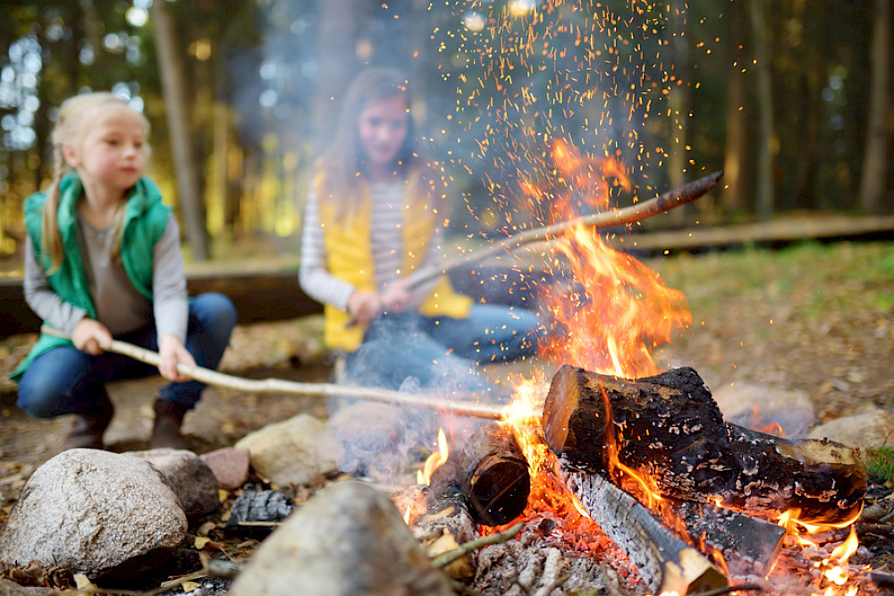 Bild zeigt zwei Mädchen am Lagerfeuer.